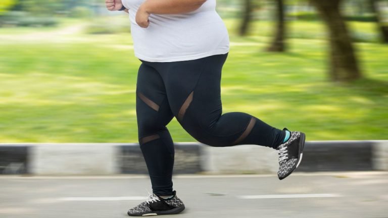 Foto com o foco nas pernas e pés de uma pessoa com obesidade correndo
