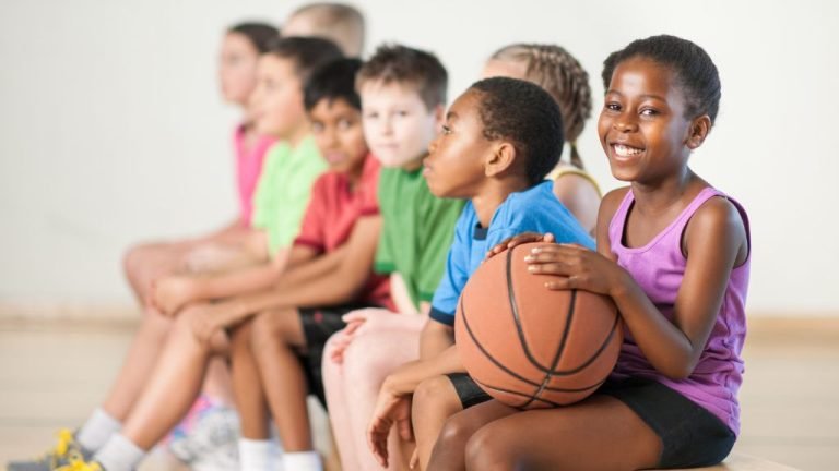 Crianças sentadas segurando objetos de Esportes para Crianças